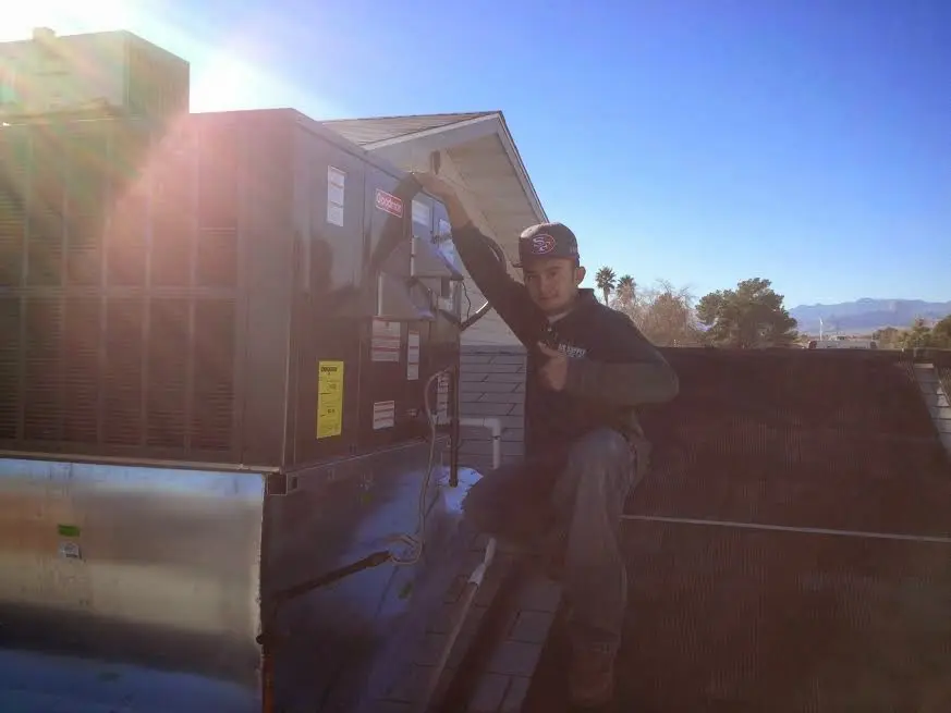 HVAC technician performing Air Duct Repair on a rooftop unit in Denton